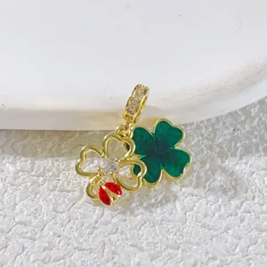 Gold-plated double four-leaf clover pendant charm with green enamel and a cute red ladybug accent.