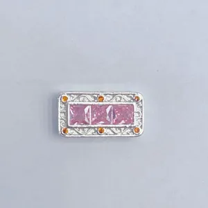 Primo piano dettagliato di un ciondolo rettangolare per braccialetto fai da te con pietre rosa.