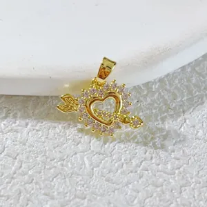 Close-up detail of a gold plated heart arrow pendant sparkling with mini cubic zirconia stones.