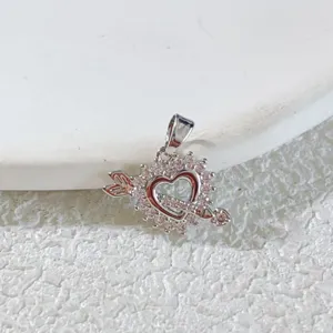 Detailed closeup of exquisite silver tone heart pierced by arrow pendant sparkling pink stones.