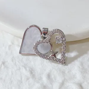 Vue détaillée du pendentif double cœur en cuivre avec zirconiums micro-sertis.