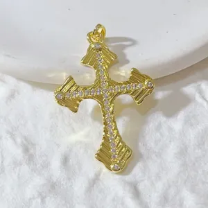 Detaillierte Nahaufnahme eines vergoldeten Kreuz-Anhängers mit Zirkonia-Mikropavé-Besatz.