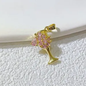 Nahaufnahme Detail des vergoldeten Weinglas Anhängers mit funkelnden rosa Zirkonia Steinen.