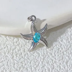 Detailaufnahme des blauen Seestern-Anhängers, minimalistischer vergoldeter Modeschmuck.