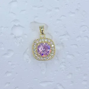 Nahaufnahme des vergoldeten quadratischen Pave-Anhängers mit funkelnden rosa Zirkoniasteinen.