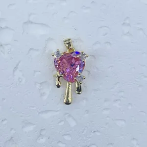 Nahaufnahme eines rosa Herz-Kristallanhängers mit Gold-Tropf-Design und Zirkon-Besatz.