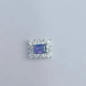 Dettaglio in primo piano di zircone viola rettangolare e strass chiari ciondolo DIY.