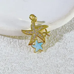 Nahaufnahme Detail eines dreifachen Seestern Anhängers, vergoldet mit Zirkonia und blauem Emaille.