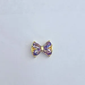 Nahaufnahme eines zarten vergoldeten Zirkon-Schleifen-Abstandshalters für DIY-Schmuck.
