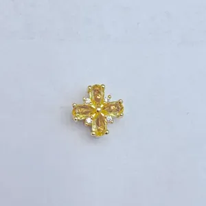 Zirkon Mikro-Pavé Kreuz Blume DIY Schmuck Komponente Detailaufnahme mit gelben Steinen.