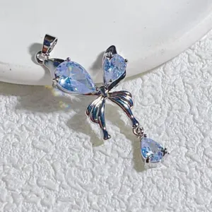 Nahaufnahme Detail des silbernen Schleifenanhängers mit funkelnden hellblauen Zirkoniasteinen.