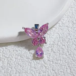 Nahaufnahme eines pinken Zirkonia Schmetterling Anhängers mit glitzernden Steinen und Metall.