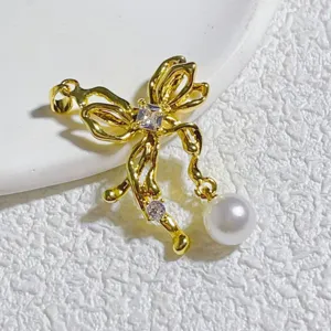 Nahaufnahme des goldenen Schleifenanhängers mit Zirkonia und Perle für DIY-Schmuck.