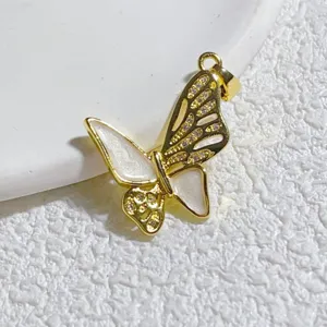 Nahaufnahme Detail des goldenen Schmetterlingsanhängers mit Zirkonia und weißer Emaille.