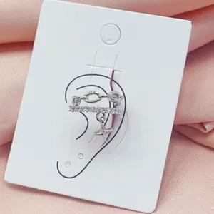Close-up of a stylish silver ear cuff with chain links, pavé crystals and a cute star charm.
