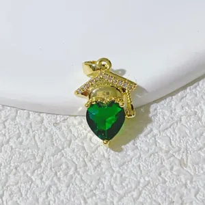 Close-up of a gold graduation cap pendant with a green heart stone and shiny cubic zirconia.
