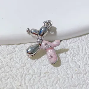 Close-up detail of silver and pink enamel balloon dog pendant for DIY jewelry making.