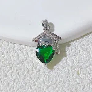 Detailed shot of a green heart crystal graduation cap pendant necklace, elegant and unique.