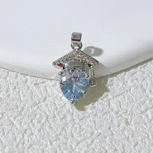 Close-up of graduation cap heart rhinestone pendant, delicate silver metal necklace detail.