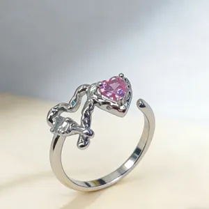 Nahaufnahme des rosafarbenen herzförmigen verstellbaren Rings mit unregelmäßigem Metallband.