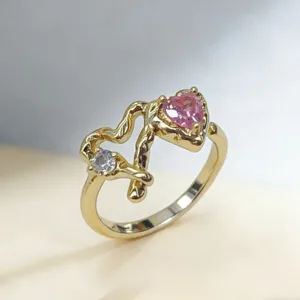 Modischer vergoldeter verstellbarer Ring mit einzigartigem Astdesign und rosa Herzstein Ansicht.