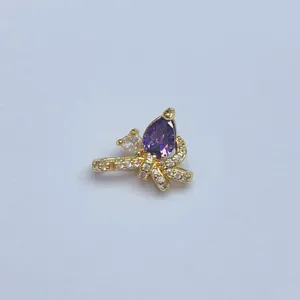 Nahaufnahme des vergoldeten Schmetterlings-Anhängers mit lila Zirkonia für DIY-Schmuck.