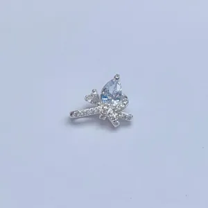 Detailaufnahme eines DIY silbernen Schleifen-Charms mit funkelnden Zirkoniasteinen für Armband.