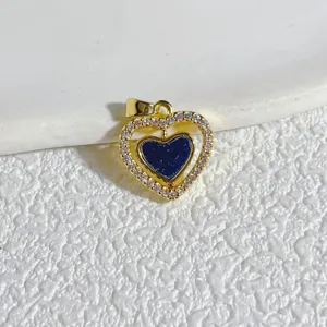 Gold plated copper heart pendant detail view with sparkling micro zircon stones and blue inlay.