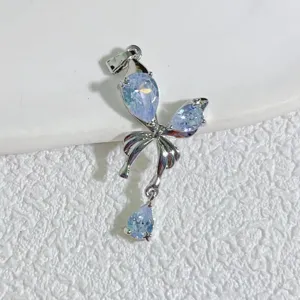 Pendentif nœud argenté élégant orné de cristaux étincoyants bleu clair en forme de goutte.