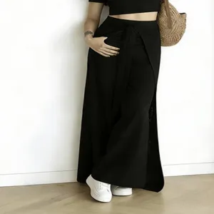 Detail view of high-waisted black wide-leg pants featuring a stylish wrap-around tie detail.