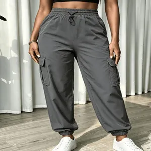 Detail shot of dark grey cargo pants with multi pockets, high waist and elastic cuffs.