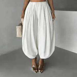 Detail view of white casual balloon pants, high waist design and cinched cuffs for women.