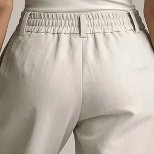 High waist pleated trousers detail shot, showcasing the elastic waist design and elegant drape fabric.
