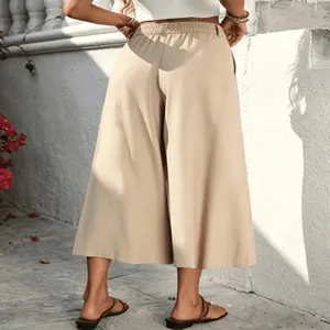 Back detail of beige high-waisted cropped wide-leg pants featuring flowing fabric.
