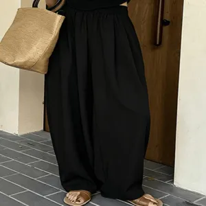 Pantaloni harem neri larghi e casual con comodo elastico in vita, dettaglio estivo sottile.