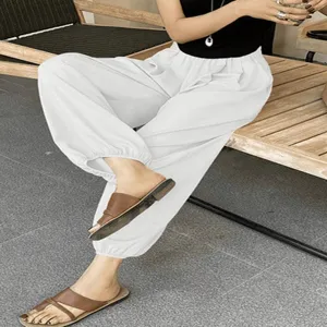 Primo piano dettagliato dei pantaloni lanterna bianchi casual larghi con vita elastica estiva.