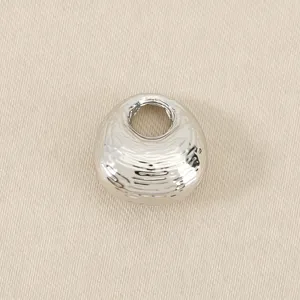 Silver metal textured fortune bag bead detail, perfect for DIY jewelry crafting and charm bracelets.