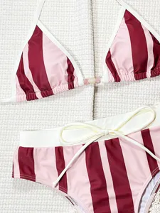 Detail shot of the pink and maroon striped two-piece bikini featuring white trim and cute center beads.