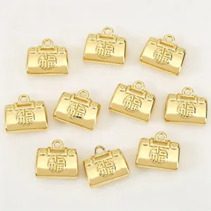 Gros plan de pendentif en forme de sac doré brillant avec caractère Fu porte-bonheur pour bijoux DIY