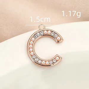 Closeup detail of pearl rhinestone inlaid letter C pendant, polished copper, perfect DIY jewelry.
