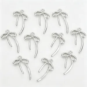 Gedetailleerd overzicht van zilveren asymmetrische strik metalen bedels voor DIY sieraden.