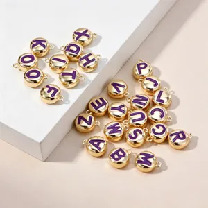 Nahaufnahme von goldenen lila Emaillierte Buchstaben Charms für DIY Halsketten Zubehör.