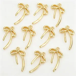 Detail van gouden asymmetrische strik bedel, gladde vergulde hanger voor DIY sieraden accessoires.