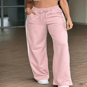 Pantaloni tuta larghi rosa da donna con bande laterali, vita elastica e cordino regolabile.