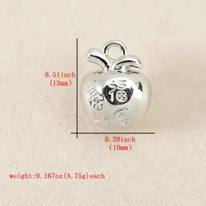 Nahaufnahme eines silberfarbenen Apfel Anhängers mit chinesischen Schriftzeichen Relief Details