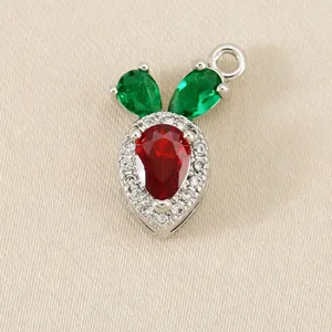 Detailed close-up of a carrot shaped pendant with red and green stones and sparkling white zircons.
