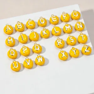 Gedetailleerd overzicht van kleurrijke emaille letterbedels, gele DIY alfabet hangers voor sieraden.