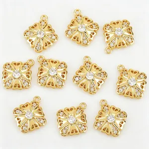 Détail en gros plan de pendentifs fleur creuse à quatre pétales plaqués or et zircon pour DIY.