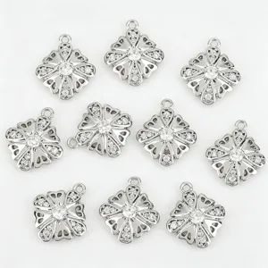 Gros plan de pendentifs de fleurs ajourées en métal argenté incrustés de zircone cubique.