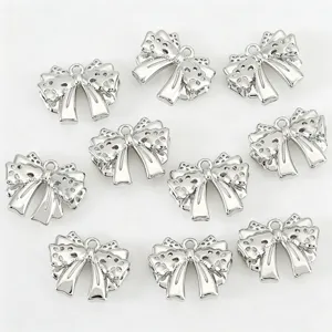 Silver hollow bow charms for DIY jewelry making, detailed pendant close-up view.